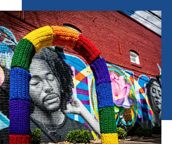 A colorful mural of a man with dreadlocks and a rainbow colored arch.